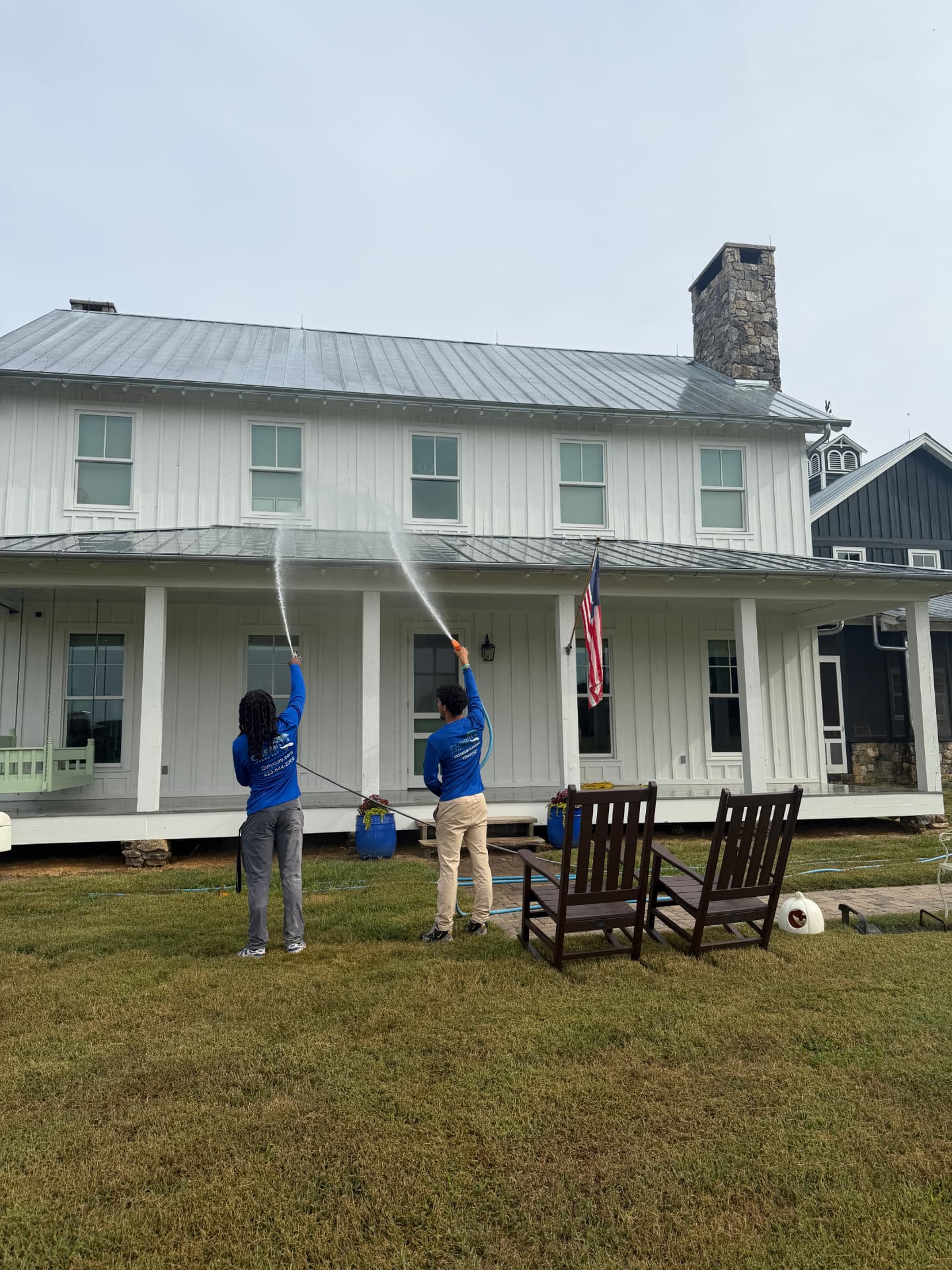 The Curb Appeal crew soft washing the exterior of a home