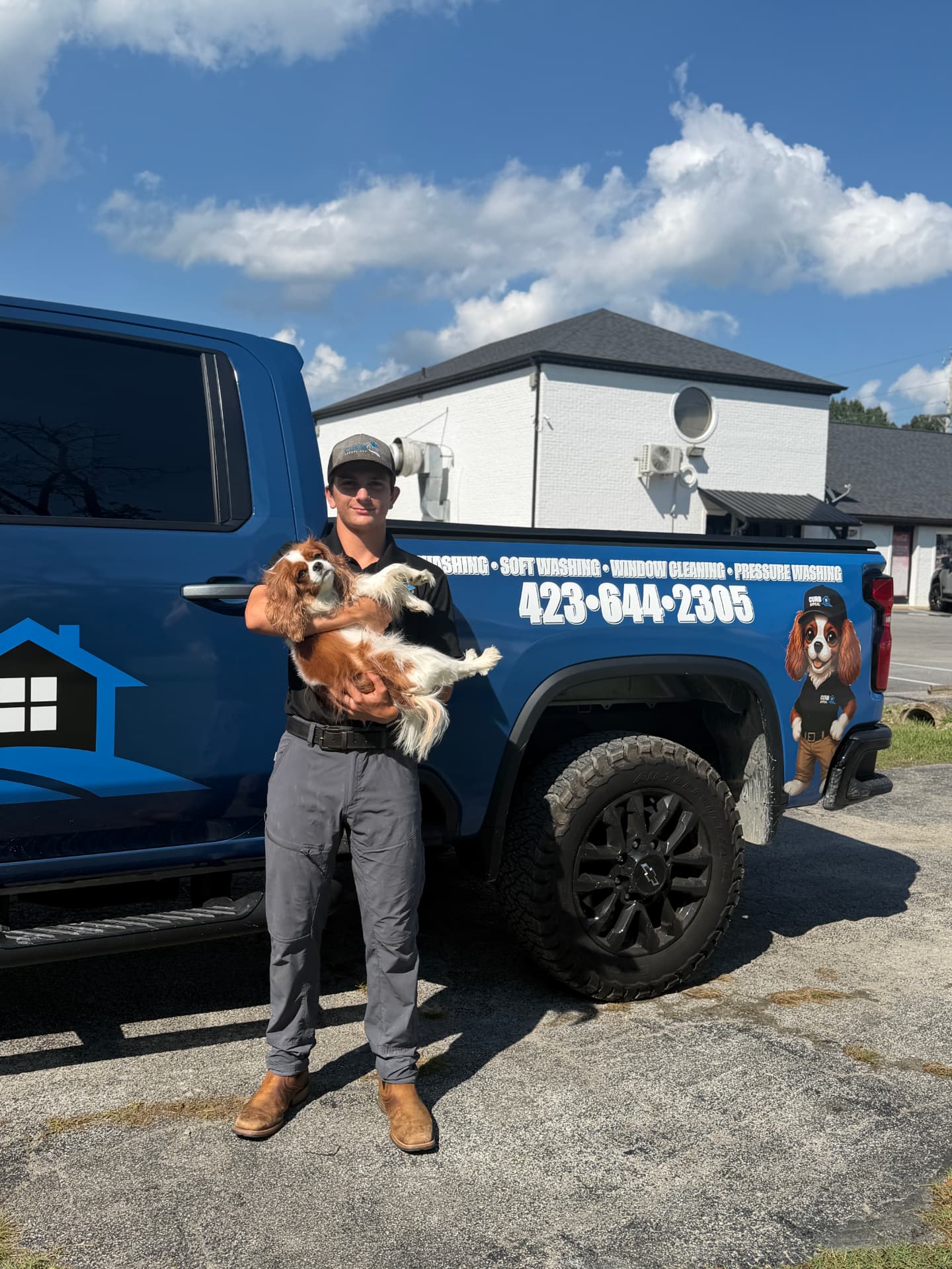 Curb Appeal team member with the company dog next to the truck